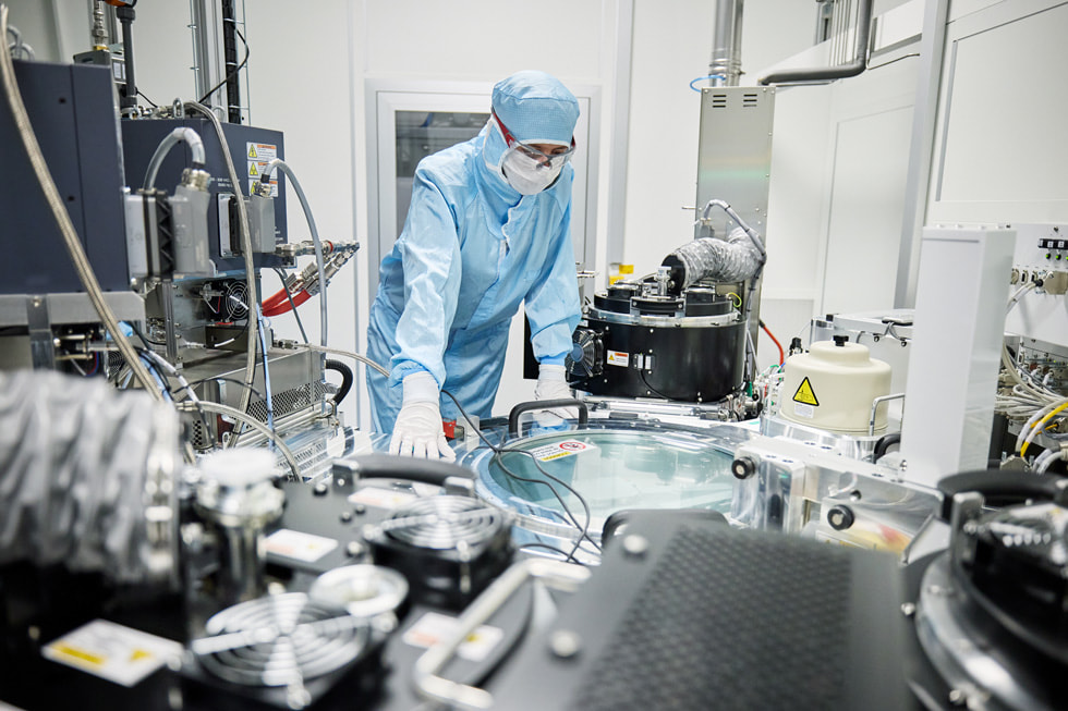 Un employé portant des équipements de protection examine un équipement au sein d’un laboratoire de l’entreprise TRUMPF Ulm.
