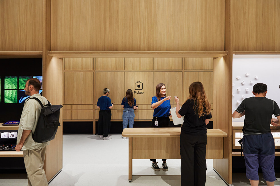 Khách hàng đang nhận sản phẩm đã mua tại khu vực nhận hàng Apple Pickup trong cửa hàng Apple Battersea ở London.