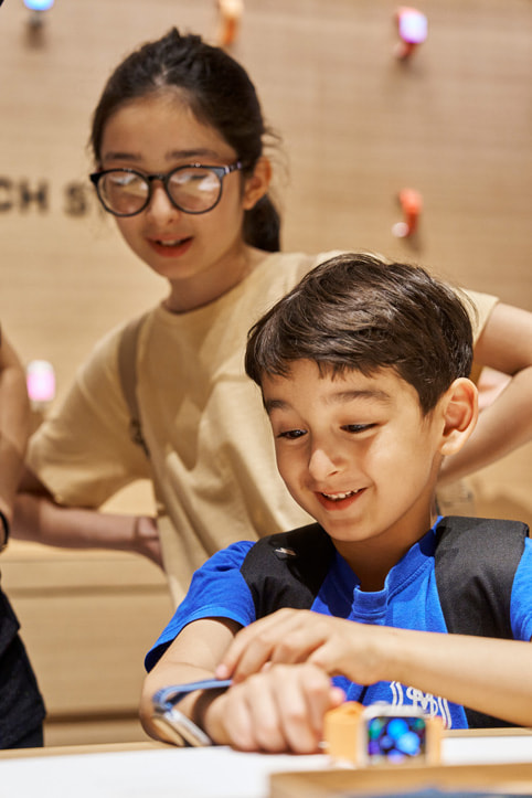 Zwei junge Kund:innen schauen sich die neueste Apple Watch Produktfamilie an.
