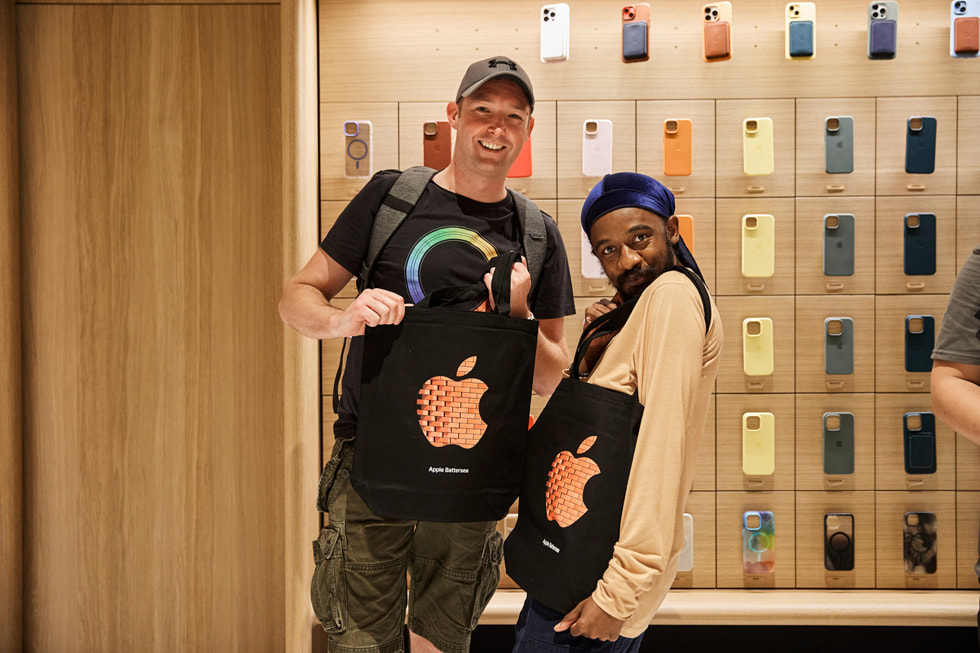 Two customers modeling Apple Battersea totes.