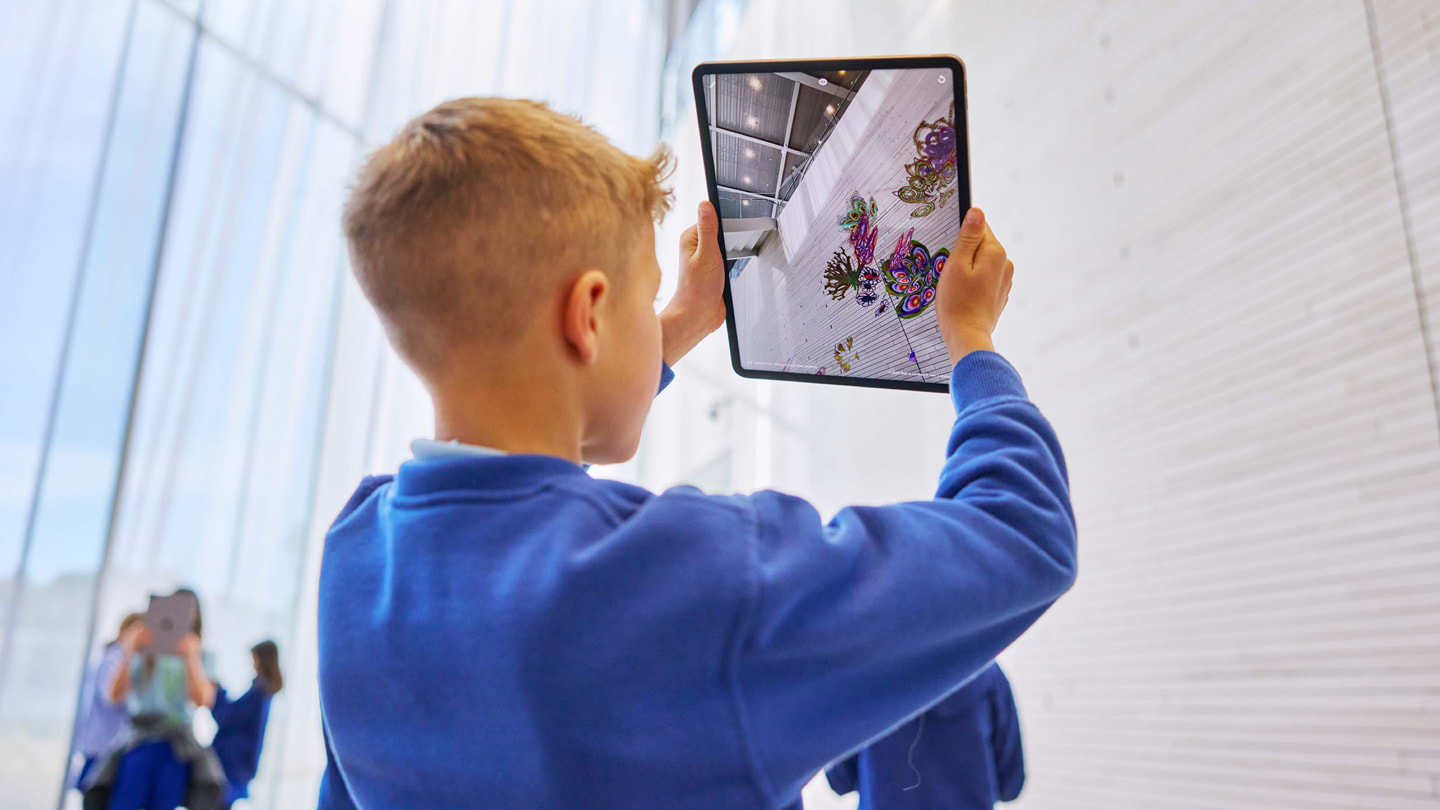 幼兒使用 iPad Pro 上的《Deep Field》app 與牆壁互動。