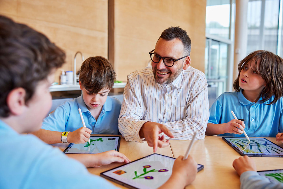 Der Künstler Edward Cutting sitzt mit jungen Künstlern zusammen, die iPad Pro und Apple Pencil nutzen.
