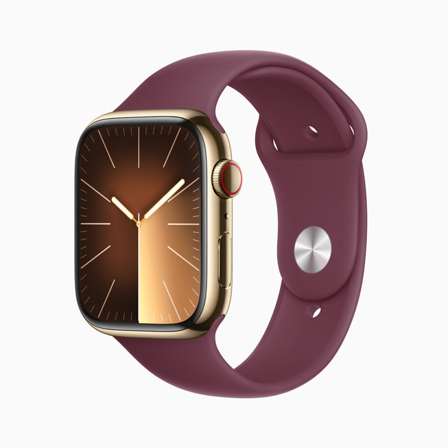 Apple Watch Series 9 i rostfritt stål med guldfinish med sportband i lila.