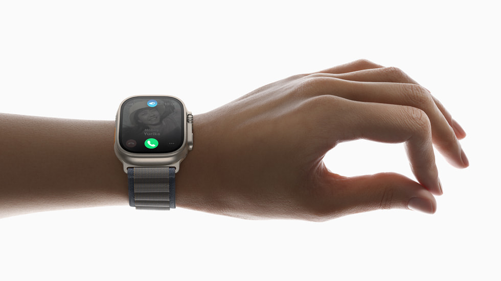 ผู้ใช้กำลังใช้คำสั่งนิ้ว "แตะสองครั้ง" ด้วยมือที่สวม Apple Watch Ultra 2