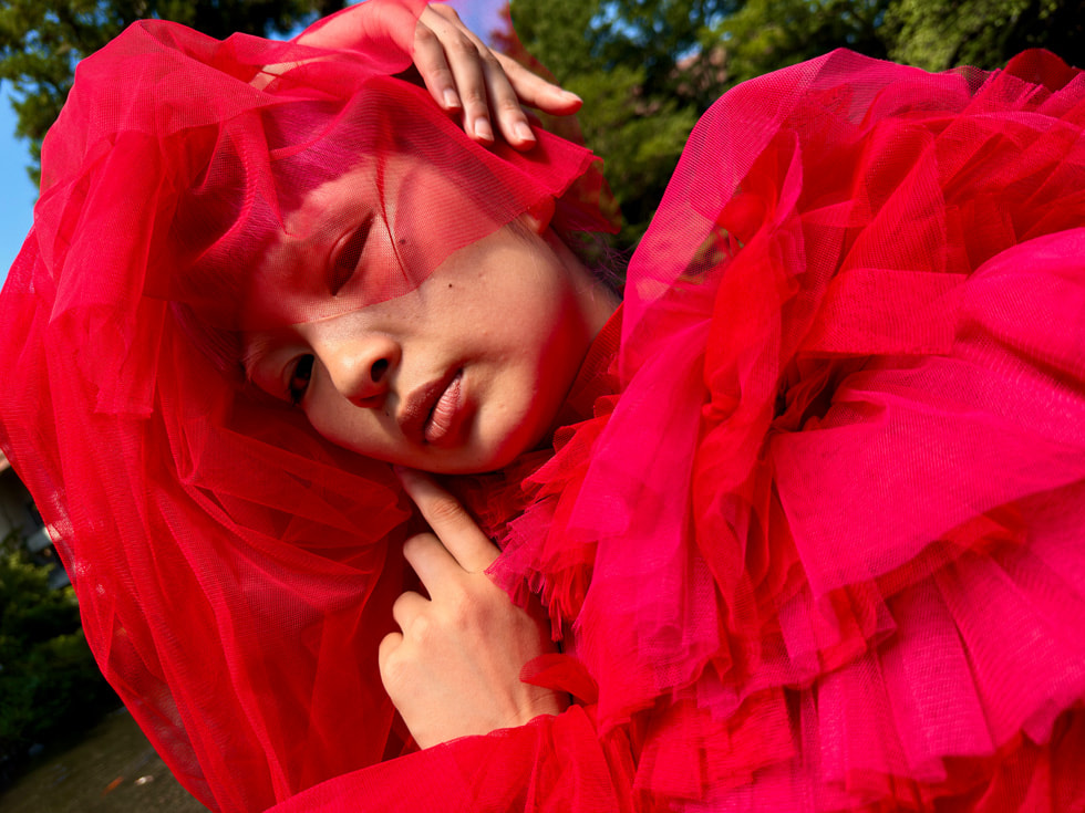 Una foto de una mujer vestida de rojo con la cámara principal de 48MP en el iPhone 15 Pro Max.