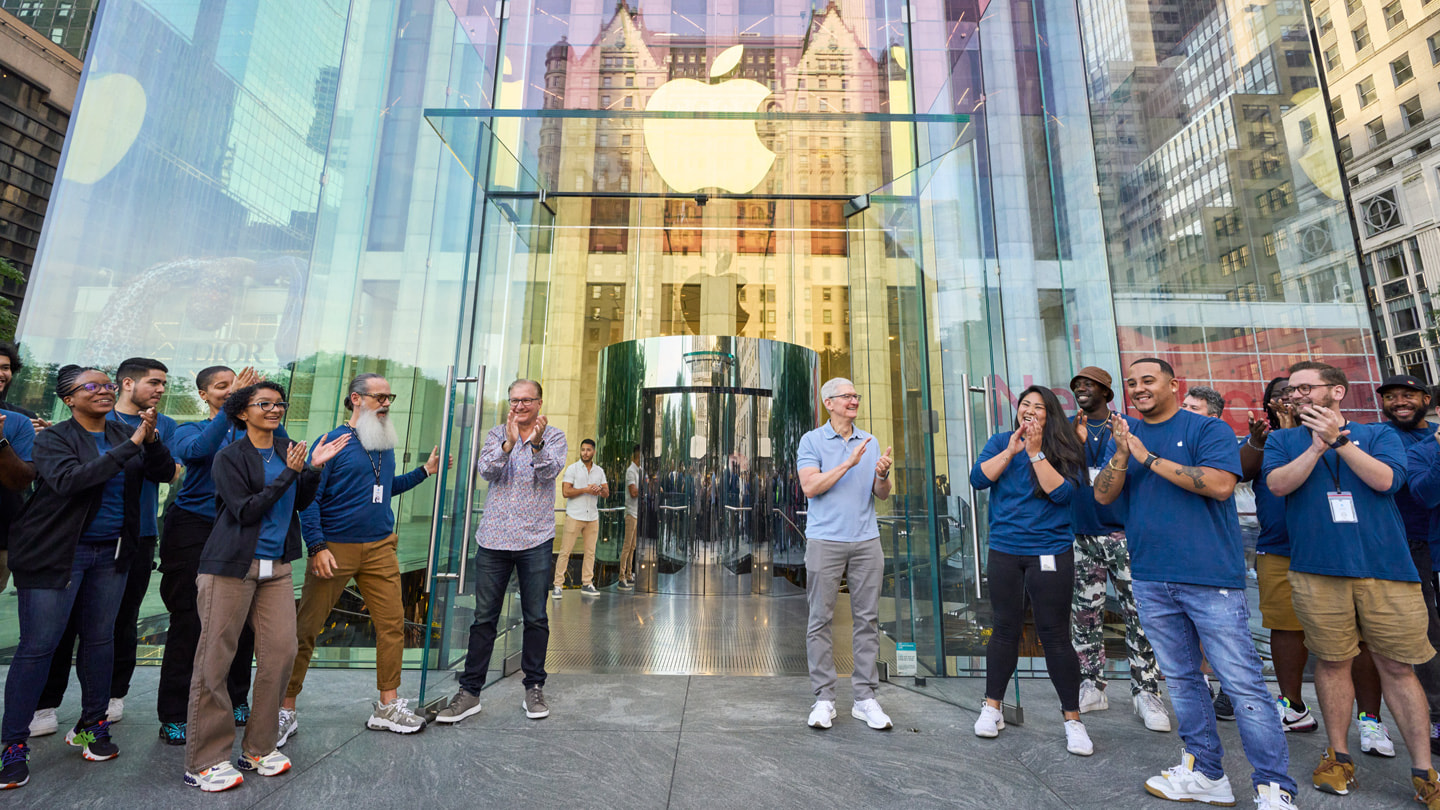 Greg Joswiak and Tim Cook welcome customers into the store.