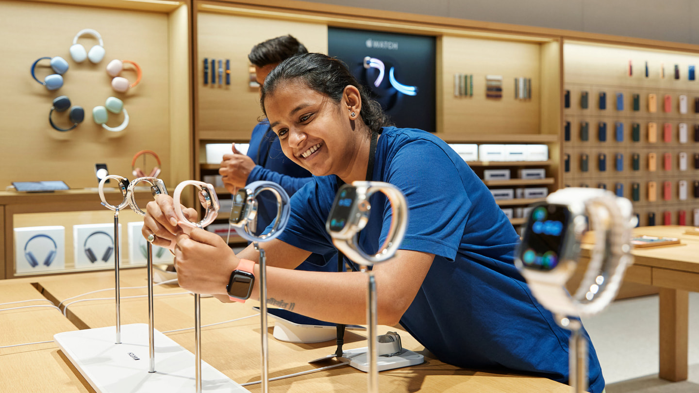 Una persona del team di Apple BKC mentre sistemai i nuovi Apple Watch Series 9 esposti su un tavolo dello store.