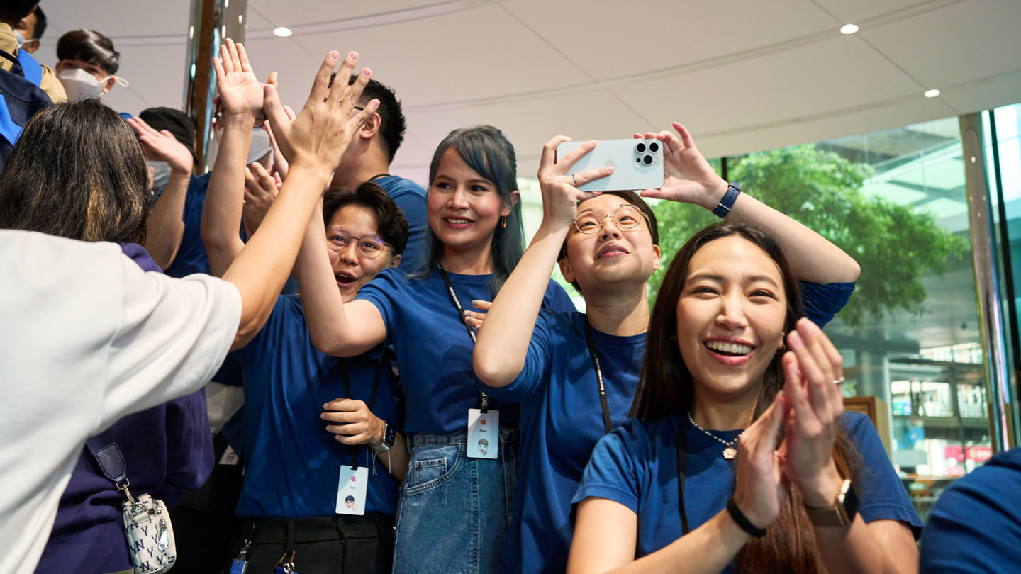 Apple Central World team members celebrate the first iPhone 15 customers to arrive at the store.