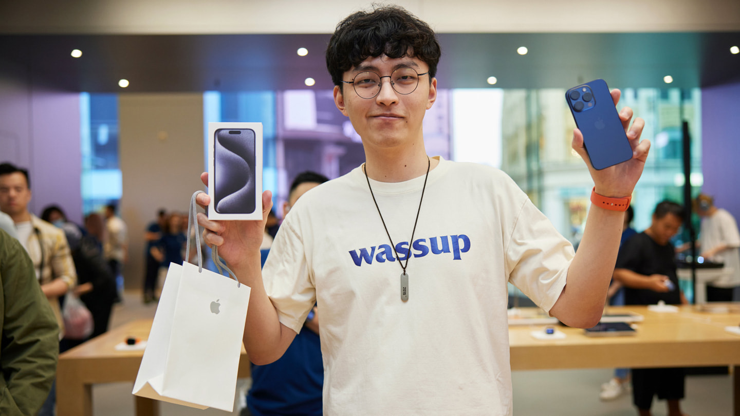 Cliente jovem mostra sua compra do iPhone 15 Pro Max azul.