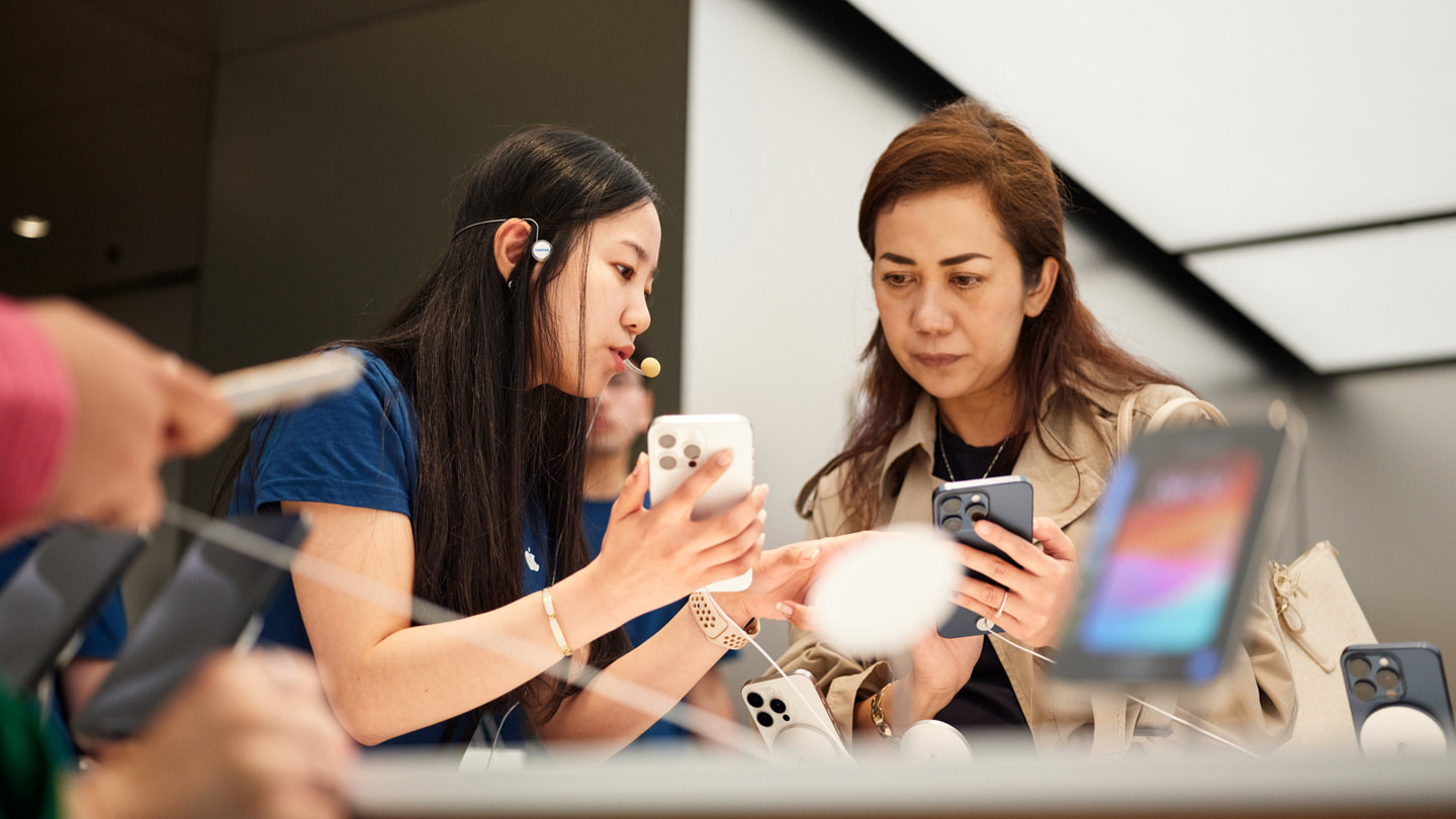 Zaměstnanec Applu pomáhá zákazníkovi s výběrem iPhonu 15 Pro v prodejně Applu v australském Sydney.