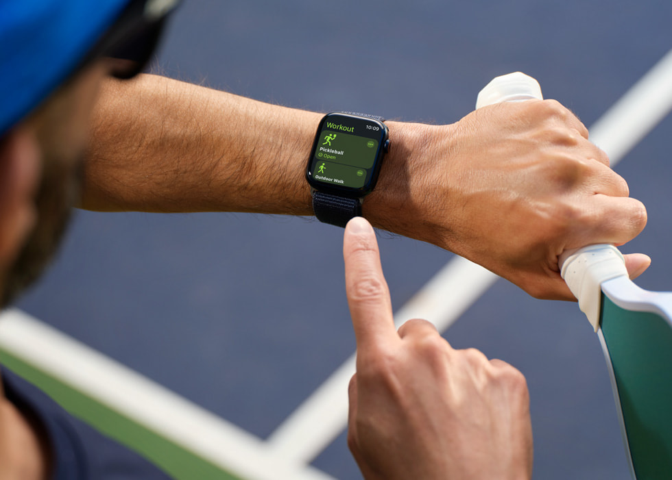 Imagen de una persona que juega al pickleball mirando un Apple Watch.