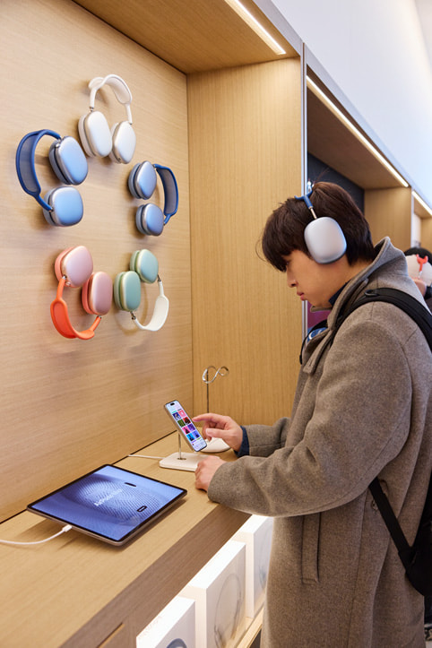 A customer tests out the AirPods Max lineup.