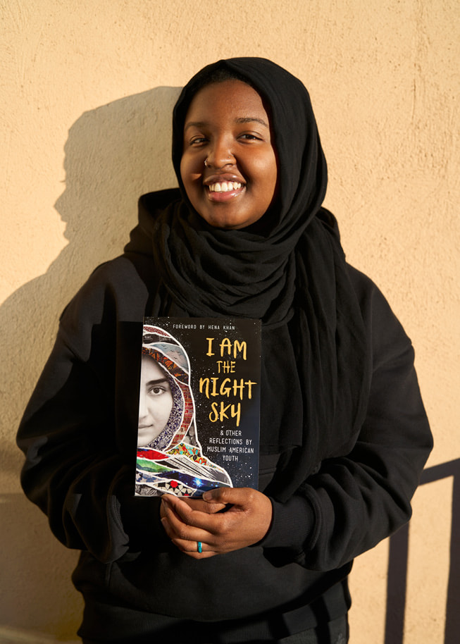 Shout Mouse Press-deltagaren Sasa Aakil poserar med ett exemplar av boken I Am the Night Sky, som hon har varit med och skrivit.