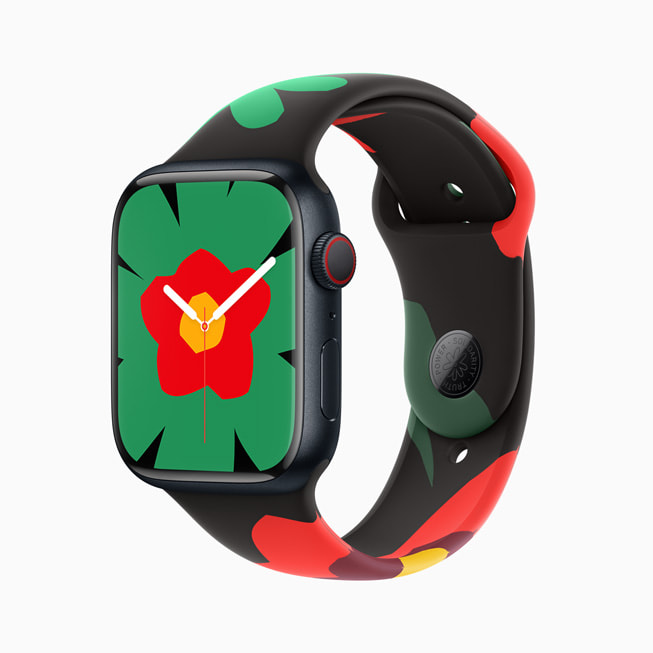 Apple Watch Series 9 med armband och urtavla från den nya Black Unity-kollektionen. Urtavlan på den här bilden pryds av stor grön blomma som är röd och gul i mitten.