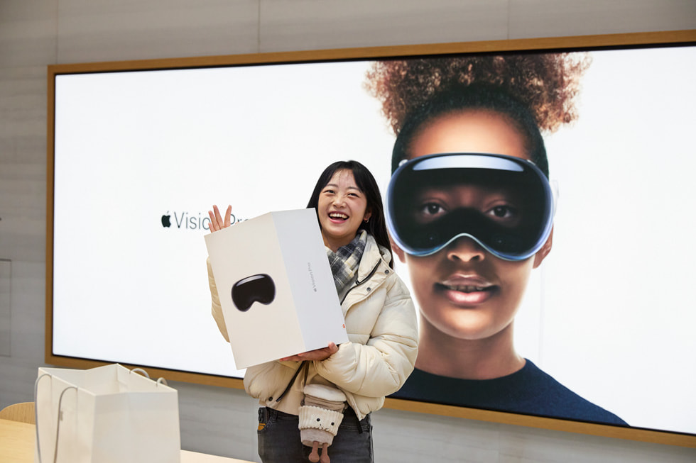 Una mujer joven posando con su compra de Apple Vision Pro.