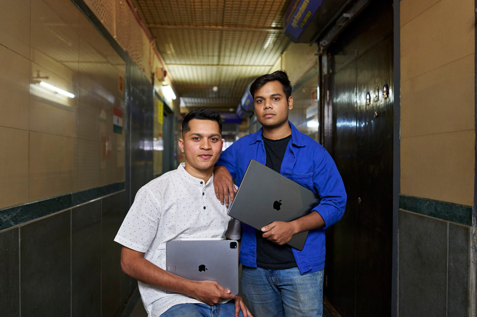 Ameya Shinde, iPad Pro en main, pose avec Aaron « Myles » Pereira et son MacBook Pro. 