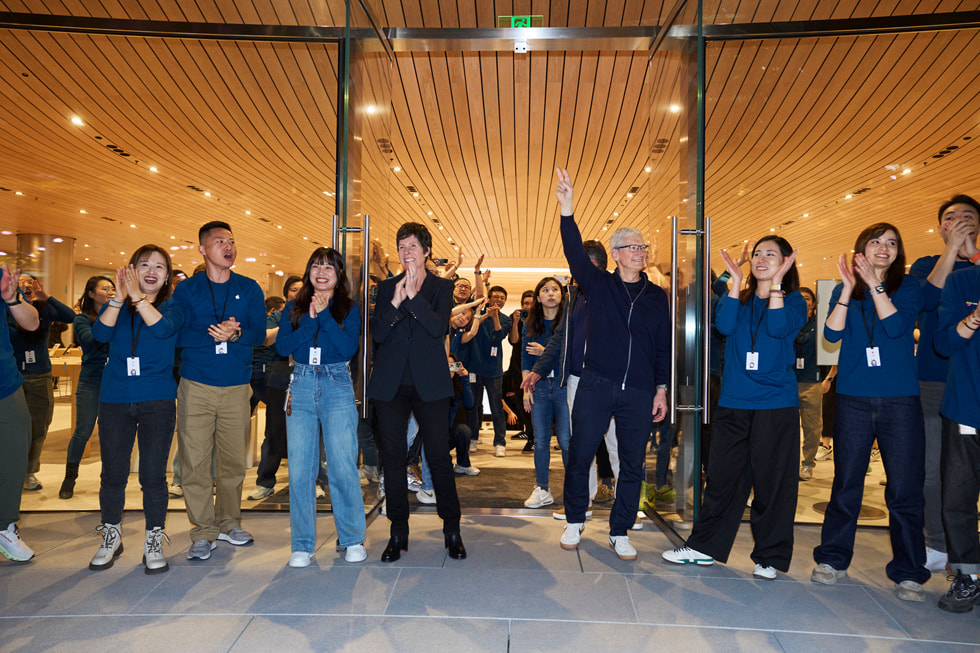 Deirdre O’Brien and Tim Cook hold open the doors at Apple Jing’an.