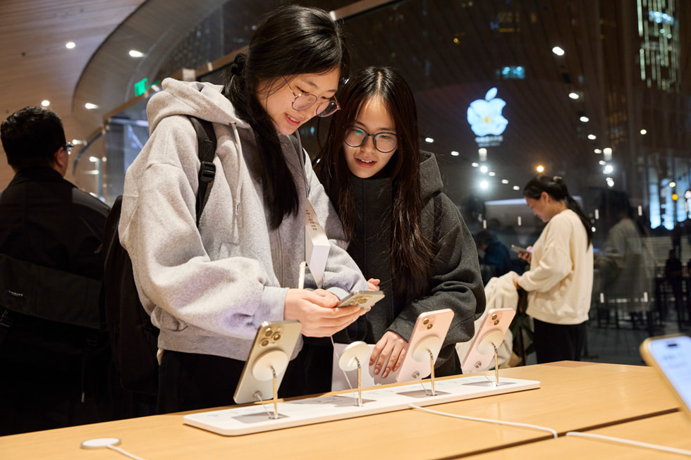 Kund:innen an einem Tisch mit dem iPhone 15 Lineup in Apple Jing’an.