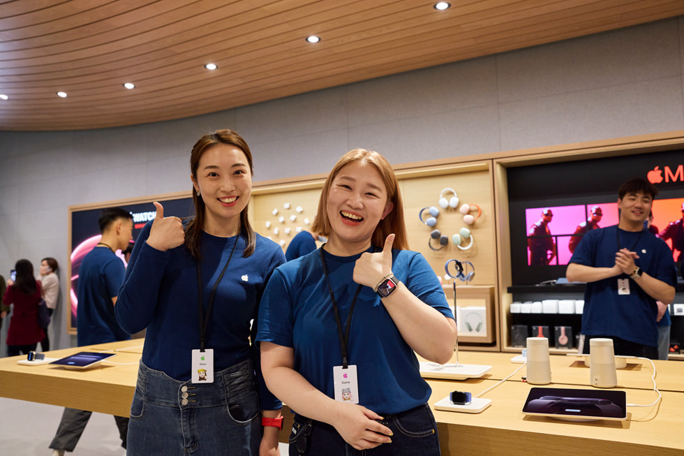 ทีมงานที่ยิ้มแย้มแจ่มใสโพสท่าถ่ายรูปที่ Apple Jing’an