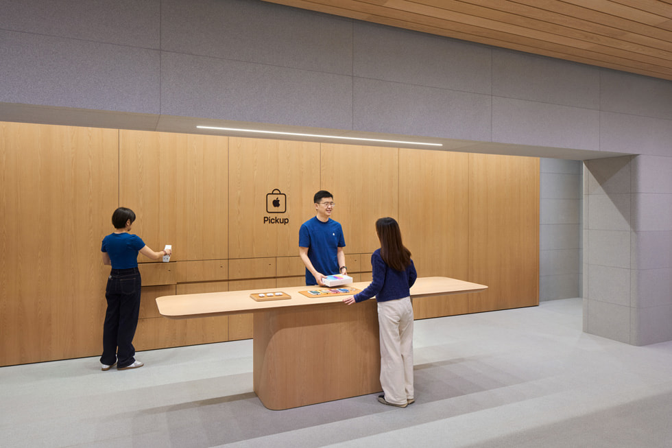 A team member helps a customer at the Apple Pickup station inside the store.
