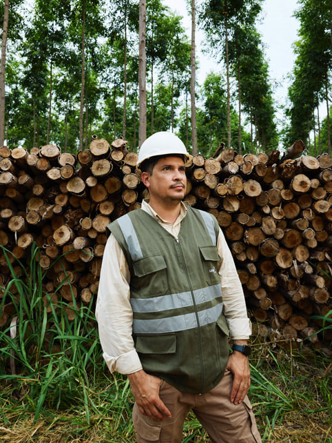 Alvaro Ramirez vor einem Holzstoss.