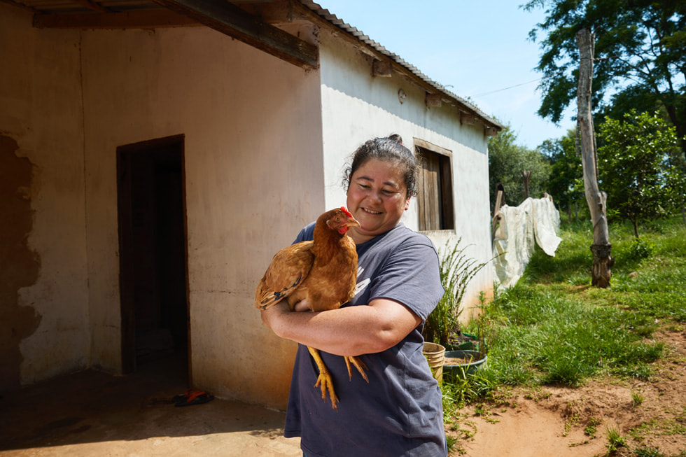 Graciela Gimenez holds a chicken in her arms.
