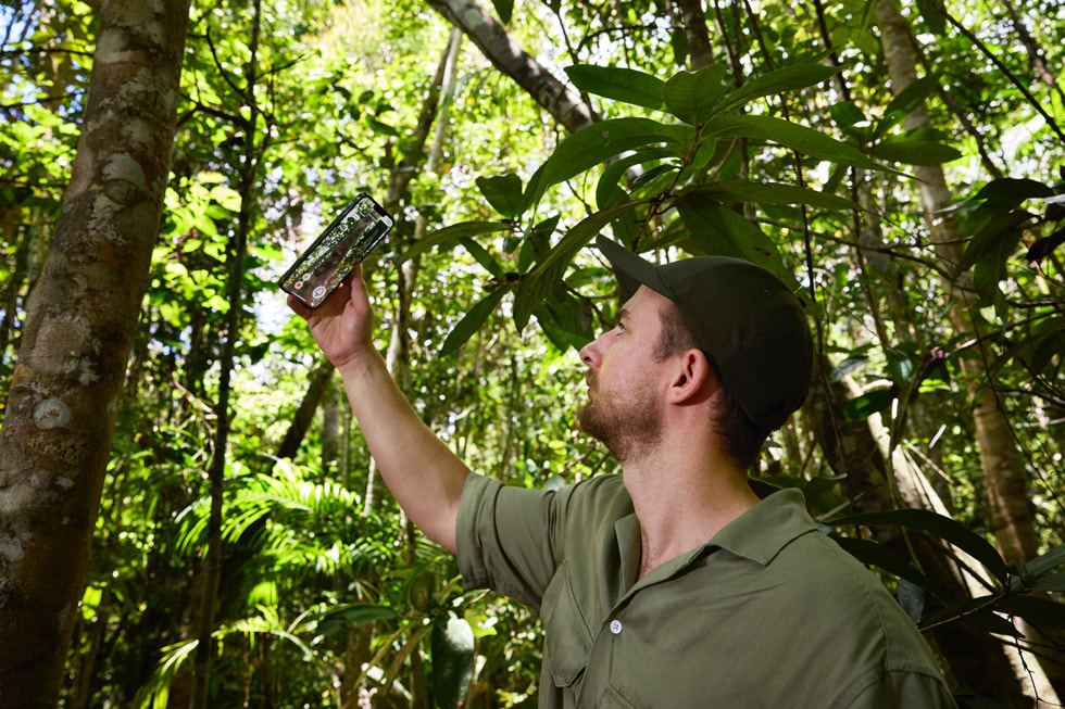 A Symbiosis worker holds up iPhone to gather data using the LiDAR Scanner and ForestScanner app.