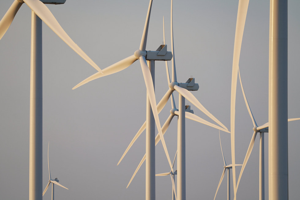 오리건주 소재의 풍력 발전 지대. 푸른 하늘을 바탕으로 여러 흰색 터빈이 세워져 있다.