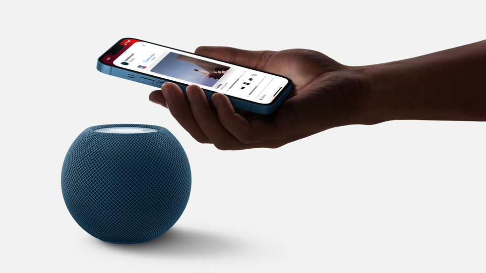 A user holds their iPhone over their HomePod speaker.