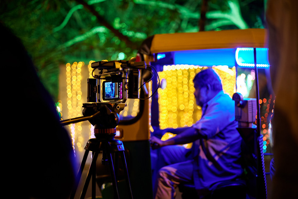 iPhone 15 Pro Max in a small rig cage on a Sachtler tripod films an actor sitting in a rickshaw for Saumyananda Sahi's film "A New Life".