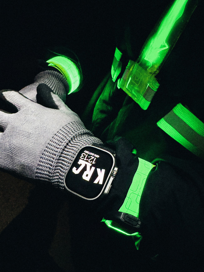 A close-up of a runner’s wrist showcasing Apple Watch Ultra at night.