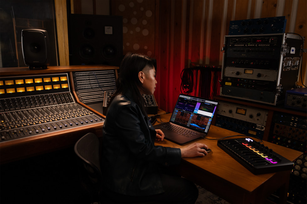 Een Logic Pro-gebruiker werkt op een MacBook Pro in een muziekstudio.