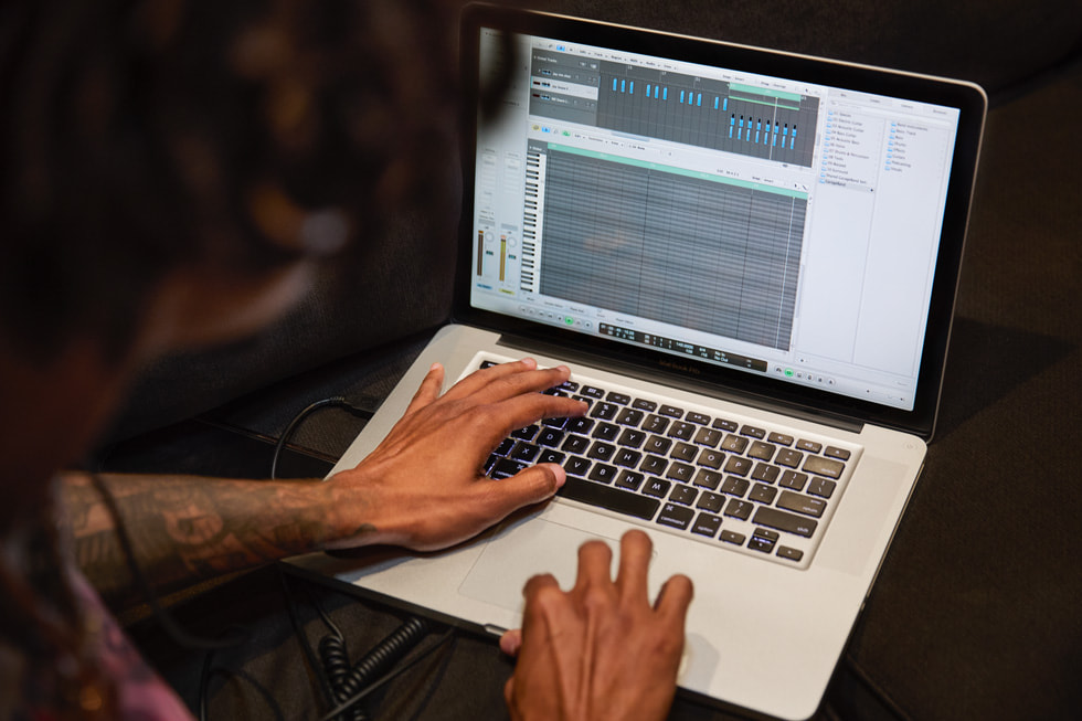 Ảnh cận cảnh Fresh Ayr đang sử dụng Logic Pro trên MacBook Pro để sản xuất bài hát.