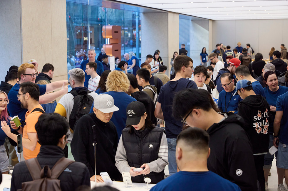 Apple team members assist excited customers inside the busy Apple Sydney store in Sydney, Australia.