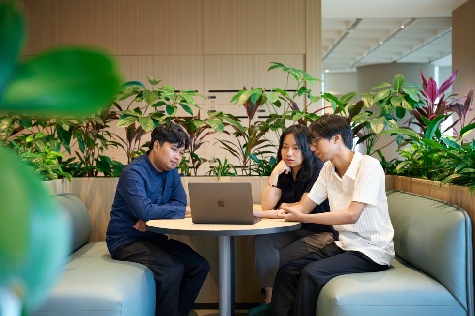 Peserta bekerja sama menggunakan MacBook di atas meja di Apple Developer Institute for Developer Operations di Indonesia.