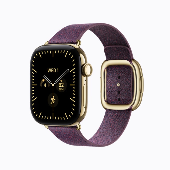 Apple Watch Series 12 ze zářivě zlatého titanu s hnědobéžovým řemínkem s moderní přezkou.