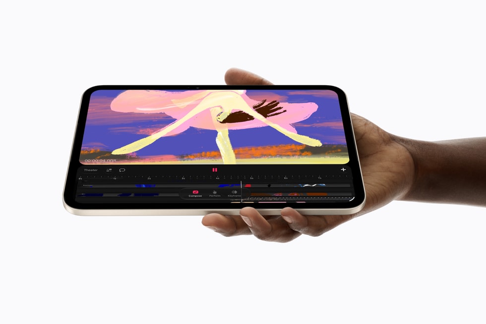 iPad mini, held in a person's hand, shows a Procreate Dreams screen.