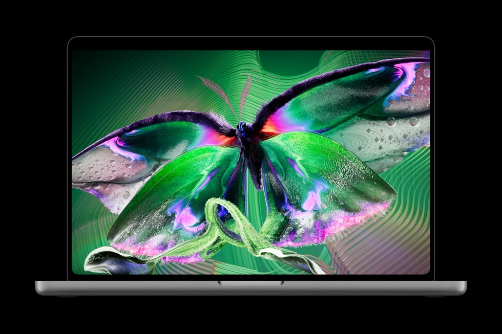 An open MacBook Pro with PROLED XDR Display shows a vibrant butterfly.