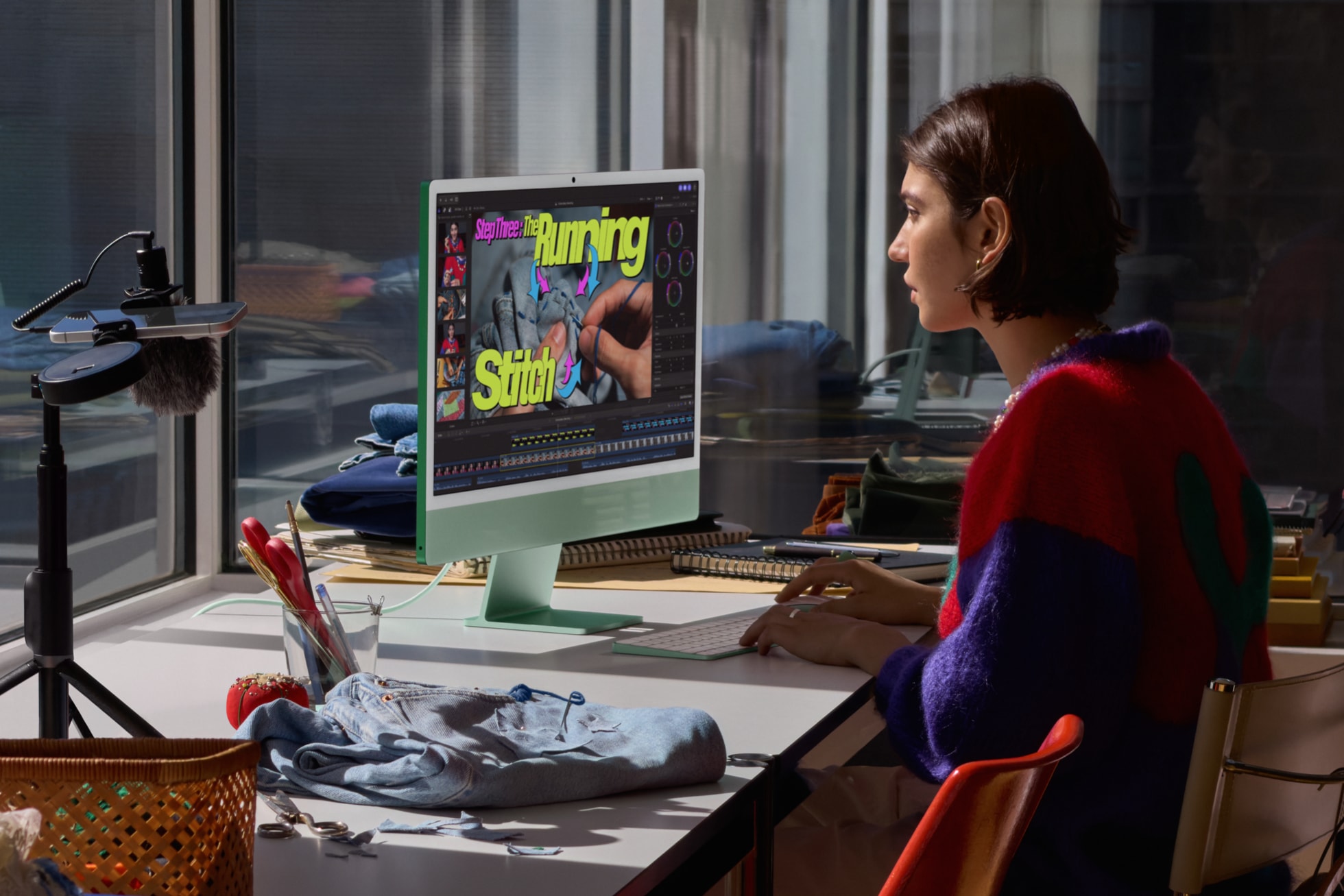 A user sits in front of iMac with M6 in green next to a sewing project while editing a video clip.