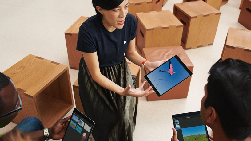 An Apple team member and two customers using iPad.