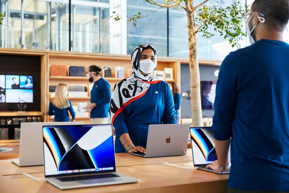 สมาชิกทีม Apple Al Maryah Island กำลังจัดโต๊ะแสดง MacBook Pro ภายในร้าน  Apple Al Maryah Island