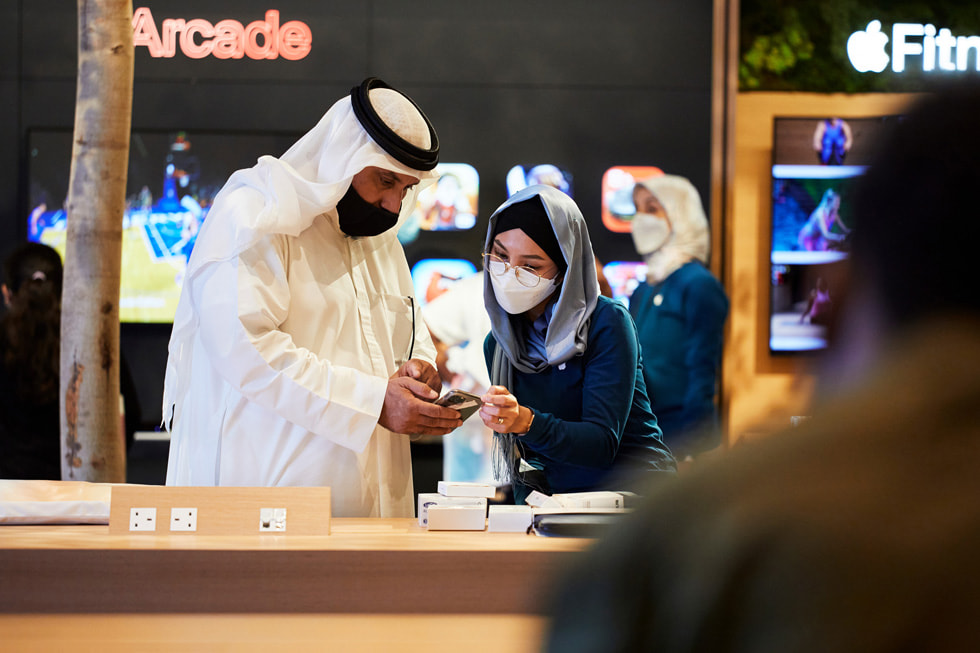 A team member assists a customer inside Apple Al Maryah Island.