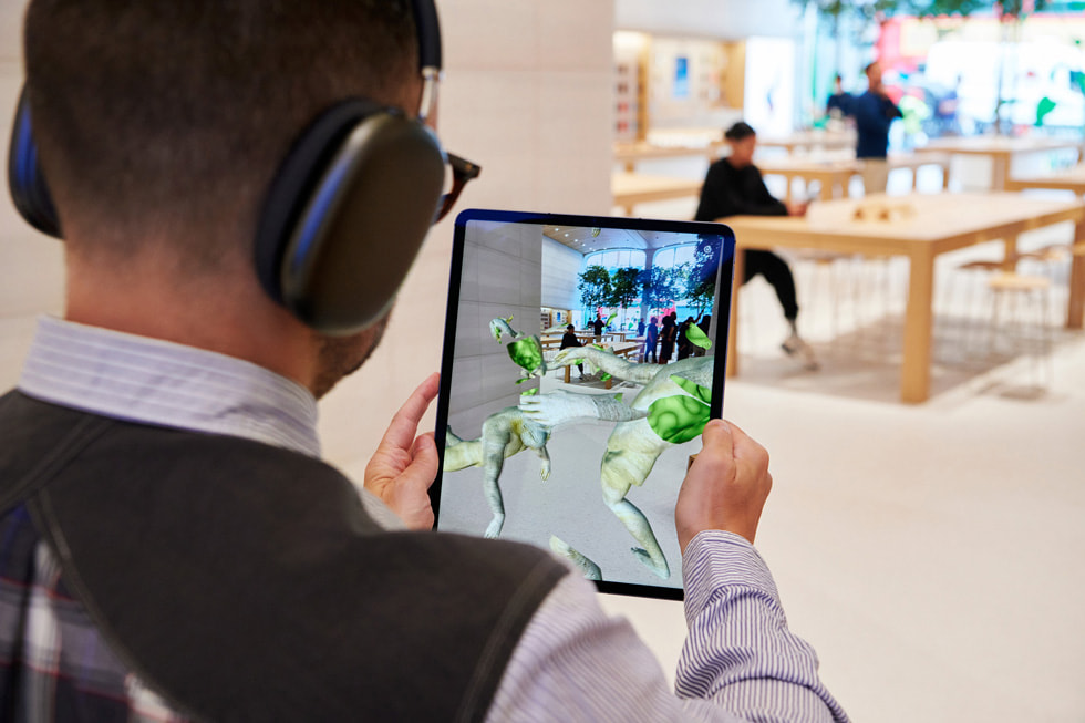 Un client tenant un iPad Pro explore l’app de réalité augmentée « United Visions ».