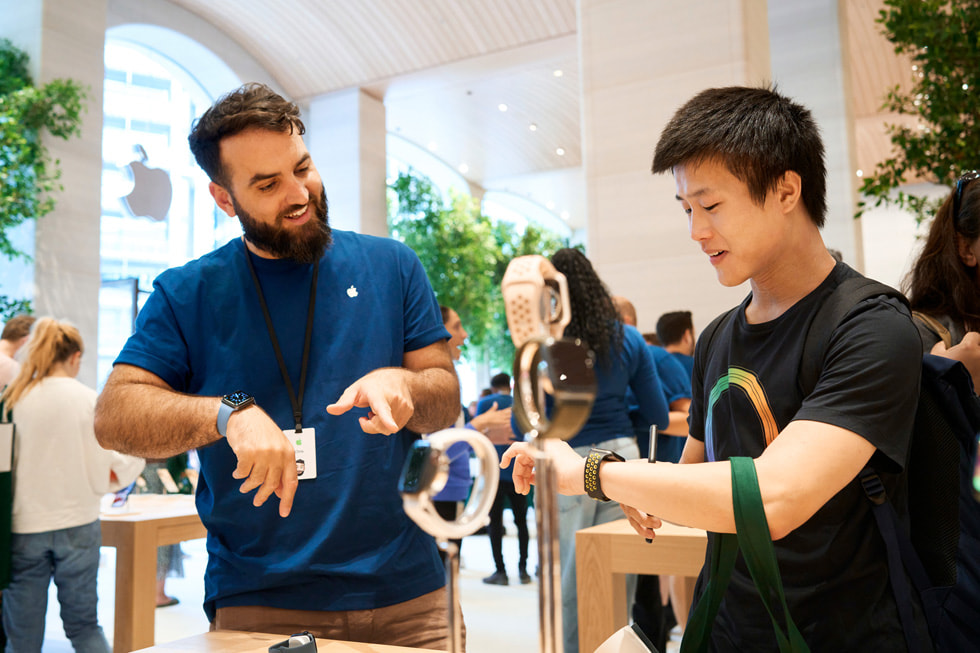 在 Apple Brompton Road 內的 Apple Watch 展示桌上，一名團隊成員正在協助顧客。
