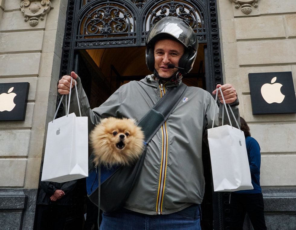 عميل يتفحص موديلاً معروضاً من عائلة iPhone 14 في متجر Apple Champs-Élysées.