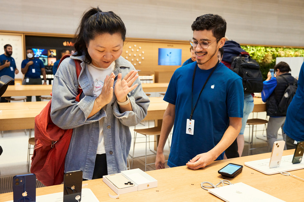 A customer unboxes her new iPhone 14 Pro in starlight.