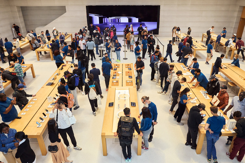 Een bovenaanzicht van het interieur van Apple Fifth Avenue, met klanten en medewerkers die kennismaken met de nieuwe producten. 