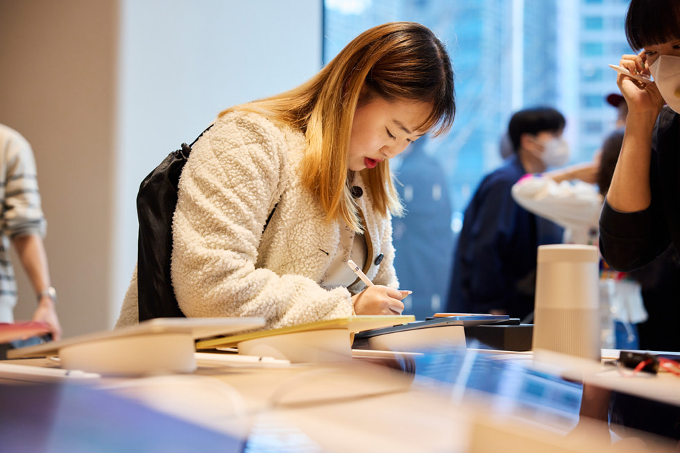 Apple 강남에서 고객이 Apple Pencil을 사용해 iPad를 살펴보고 있다.