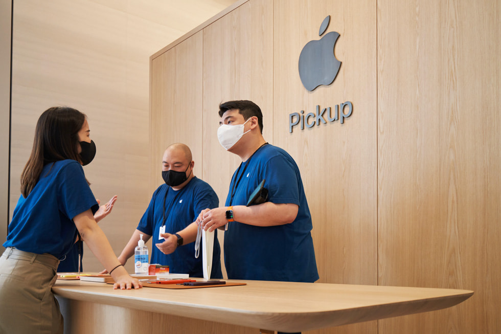 Alcune persone del team mentre parlano nell’area dedicata al ritiro in negozio di Apple Myeongdong.