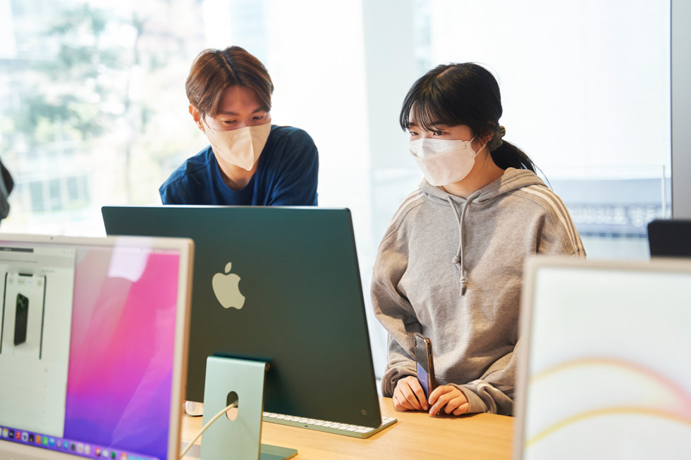 A team member assists a customer at the opening of Apple Myeongdong.